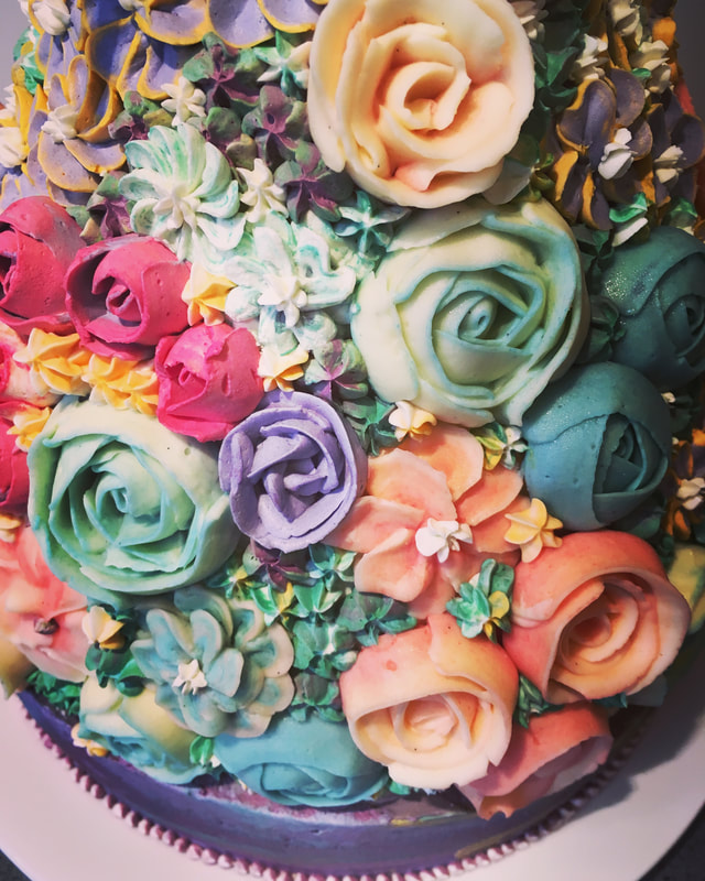 gekleurde bloemen van botercreme op een grote taart